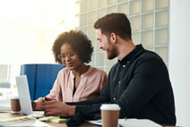 man-and-woman-talking-in-front-of-laptop