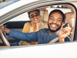 man-holding-a-car-key-with-a-woman-beside-him