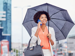 woman-on-phone-while-holding-an-umbrella